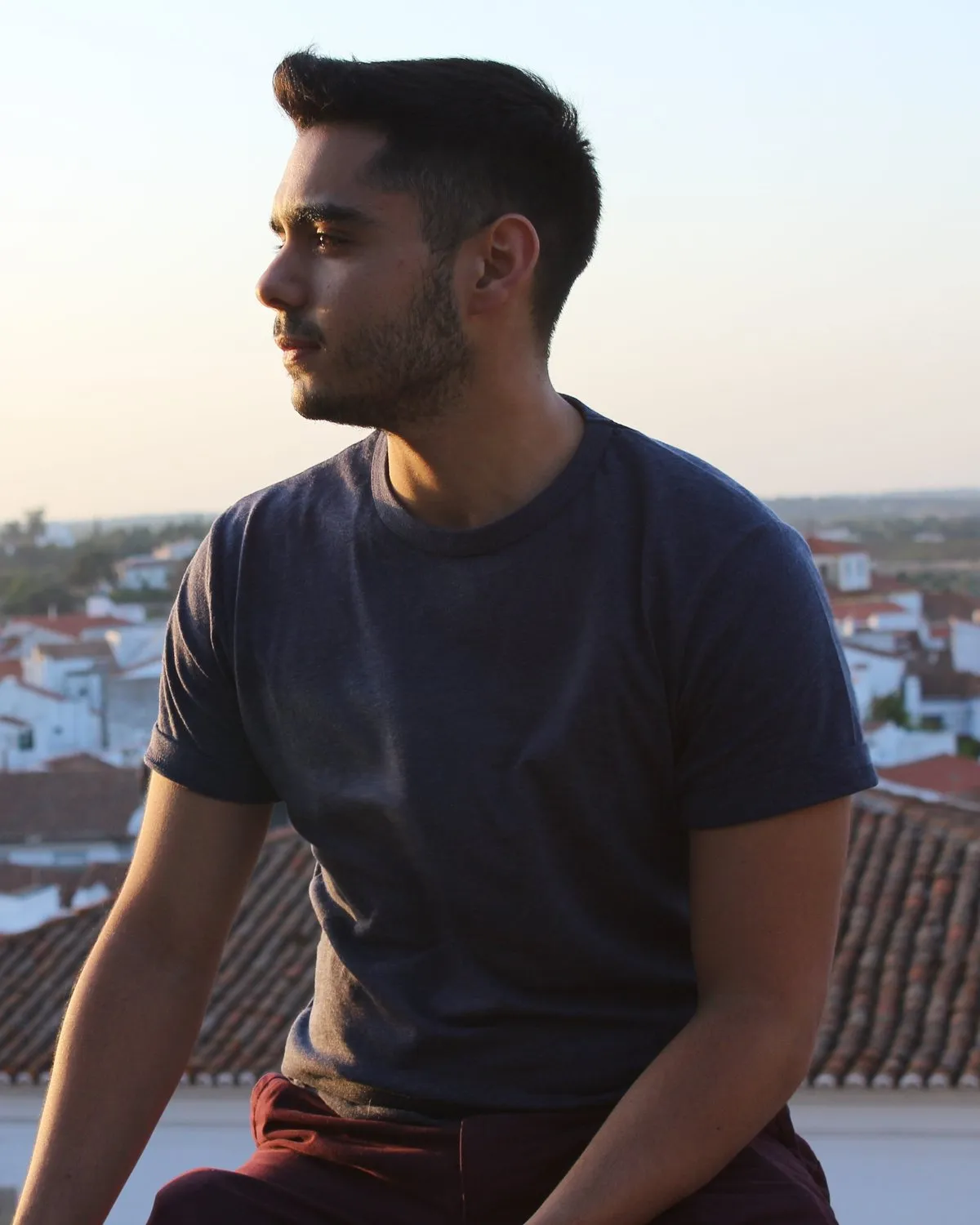 Retrato de Andrés Adriani de perfil, con camiseta azul marino, al atardecer.